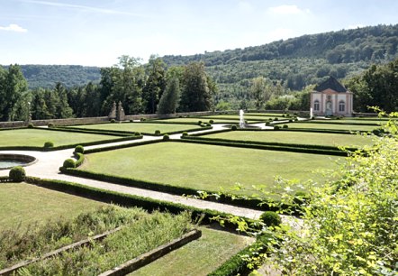 French garden with symmetrical hedges and lawns, a small building in the background and wooded hills under a blue sky., © V. Teuschler French garden with symmetrical hedges and lawns, a small building in the background and wooded hills under a blue sky., © V. Teuschler