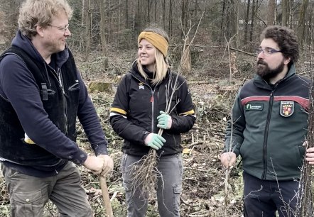 Unter der Leitung von Förster Julian Gröber haben viele Freiwillige bei der Baumpflanzaktion in Ernzen geholfen. (v. l. n. r.: Bruno Zwank und Anna Carina Krebs (Geschäftsführer und Tourismusmanagerin der Felsenland Südeifel Tourismus GmbH), Julian Gröber (Revierförster)., © Felsenland Südeifel Tourismus GmbH Unter der Leitung von Förster Julian Gröber haben viele Freiwillige bei der Baumpflanzaktion in Ernzen geholfen. (v. l. n. r.: Bruno Zwank und Anna Carina Krebs (Geschäftsführer und Tourismusmanagerin der Felsenland Südeifel Tourismus GmbH), Julian Gröber (Revierförster)., © Felsenland Südeifel Tourismus GmbH