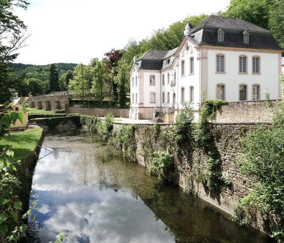 Schloss Weilerbach bei Bollendorf, umgeben von Bäumen und einem Wassergraben, unter blauem Himmel mit Wolken., © Elke Wagner, Felsenland Südeifel Tourismus GmbH Schloss Weilerbach bei Bollendorf, umgeben von Bäumen und einem Wassergraben, unter blauem Himmel mit Wolken., © Elke Wagner, Felsenland Südeifel Tourismus GmbH