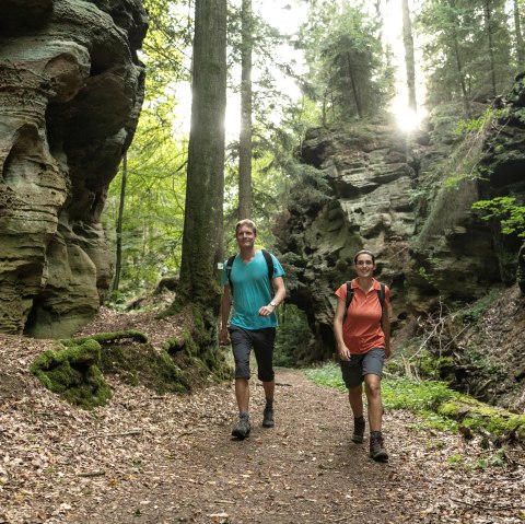 Wanderer in der "Schweineställe" genannten Schlucht im Felsenland Südeifel, © Eifel Tourismus GmbH / Dominik Ketz Wanderer in der "Schweineställe" genannten Schlucht im Felsenland Südeifel, © Eifel Tourismus GmbH / Dominik Ketz