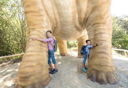 Kinder können die mächtigen Beine des Seismosaurus im Dinosaurierpark Teufelsschlucht kaum umfassen, © Felsenland Südeifel Tourismus GmbH / Dominik Ketz Kinder können die mächtigen Beine des Seismosaurus im Dinosaurierpark Teufelsschlucht kaum umfassen, © Felsenland Südeifel Tourismus GmbH / Dominik Ketz