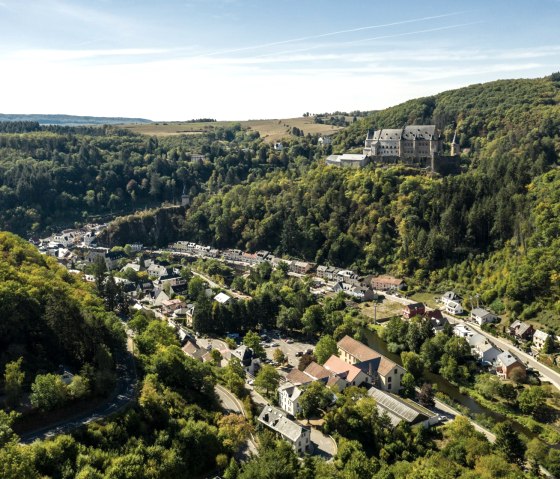 Luchtfoto van Vianden, Luxemburg, met het kasteel op een beboste heuvel en de stad in de vallei., © Eifel Tourismus GmbH, D. Ketz Luchtfoto van Vianden, Luxemburg, met het kasteel op een beboste heuvel en de stad in de vallei., © Eifel Tourismus GmbH, D. Ketz