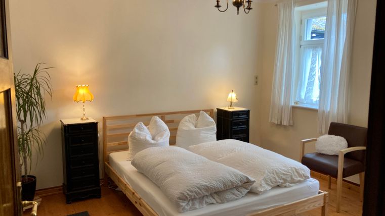 Une chambre confortable avec un lit double et des coussins moelleux. Éclairage agréable grâce aux veilleuses et à un lustre.