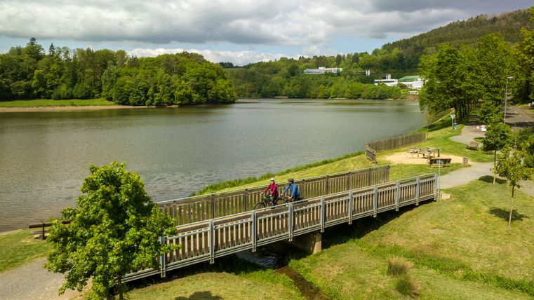 Zwei Radfahrer auf einer Brücke am Stausee Bitburg.