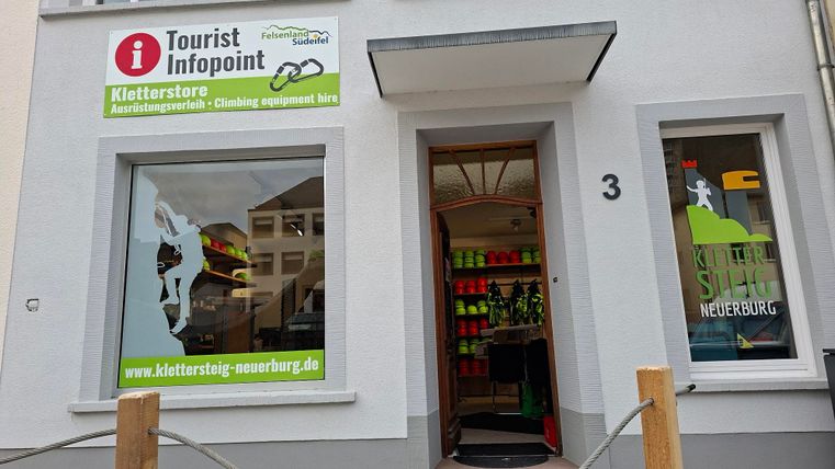 Ein Tourist-Infopoint mit einem Kletterstore. Die Fenster zeigen bunte Kletterausrüstungen und Informationsangebote.