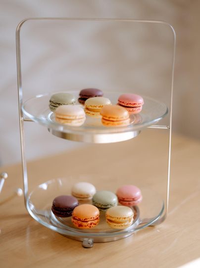 Een stijlvolle etagere met kleurrijke macarons in verschillende smaken. De macarons zijn op twee niveaus gerangschikt en bieden een aantrekkelijke presentatie.