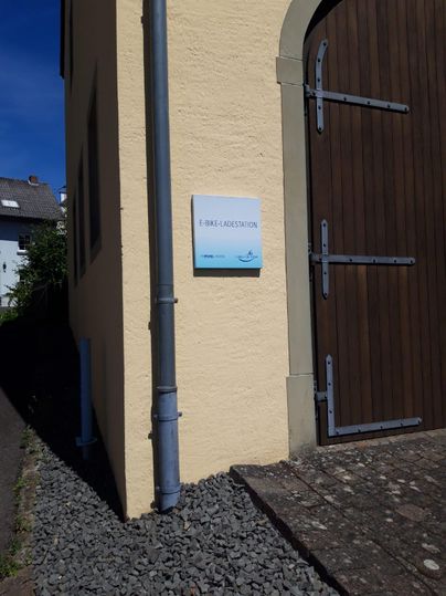 Eine E-Bike-Ladestation an einer Wand. Die Station ist gut sichtbar und freundlich gestaltet.