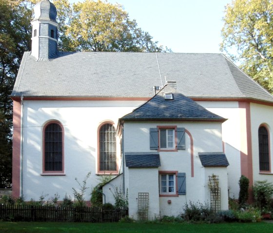 The Schankweiler Klause is a historic building with a gray roof and white walls, surrounded by trees and a garden., © Chr. Teuschler