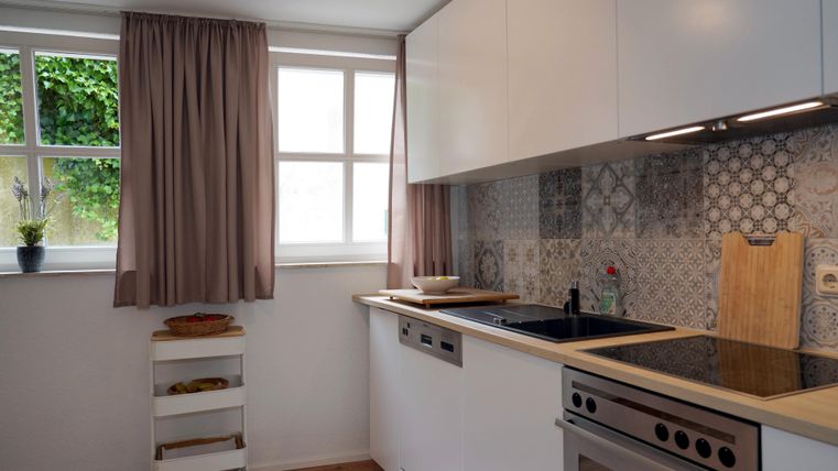 Eine helle Küche mit modernen Möbeln und einer großen Arbeitsplatte.