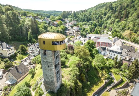 A tower with a golden viewing platform overlooks a green landscape and a small settlement. Forests can be seen in the background., &copy; Eifel Tourismus GmbH, Dominik Ketz