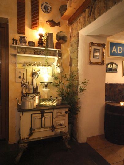 Eine gemütliche Innenansicht mit einem rustikalen Schrank und dekorativen Gegenständen. Das warme Licht schafft eine einladende Atmosphäre.