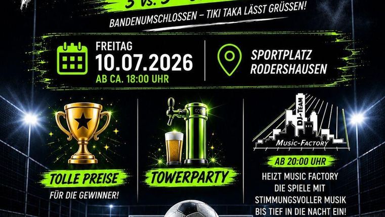 Eine Gruppe von Personen steht zusammen und lächelt auf einem Gelände. Sie tragen schwarze T-Shirts und befinden sich in einer sonnigen Umgebung mit Bauzäunen im Hintergrund.