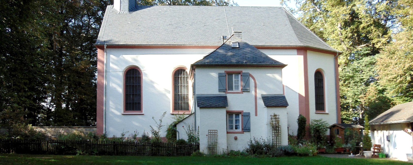 Schankweiler Klause, ein historisches Geb&auml;ude mit wei&szlig;en W&auml;nden und roten Akzenten, umgeben von B&auml;umen., &copy; Chr. Teuschler