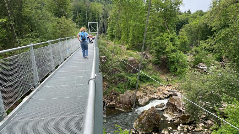 Une femme traverse le pont suspendu au-dessus des chutes d'Irreler.